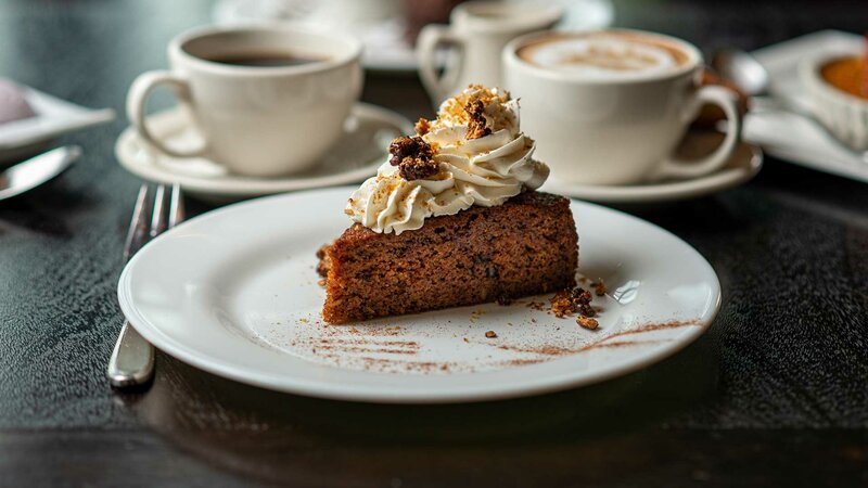 Cake dessert topped with whipped cream and nuts